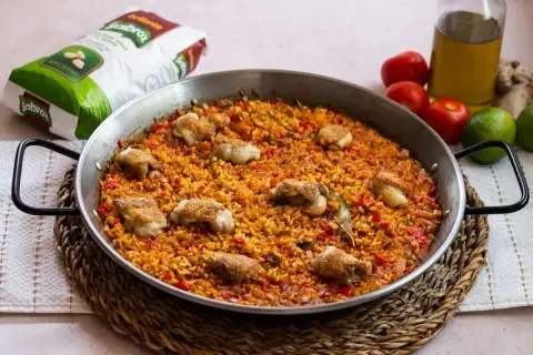 Paella de arroz con alitas de pollo, un plato lleno de sabor y color, listo para compartir.