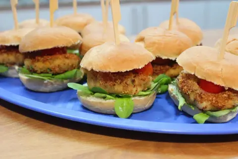 Mini burgery z kotletem w panierce, sałatą i pomidorkiem. Idealne gorące dania na sylwestra w domu.
