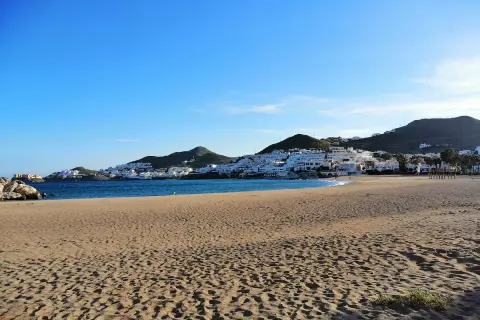 Playa de San José, con casas blancas en la ladera y el mar azul. ¡Qué carallo de vista!