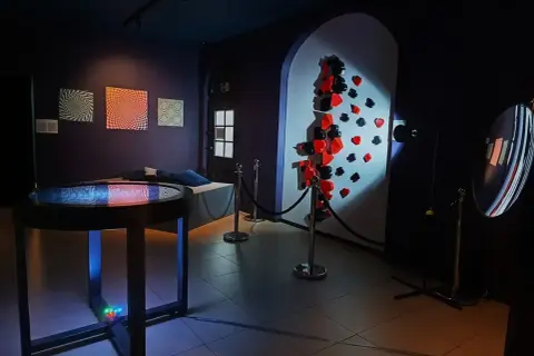 W muzeum iluzji Warszawa zobaczysz optyczne triki i instalacje, jak ściana z kartami i stołem z efektem wodnym.