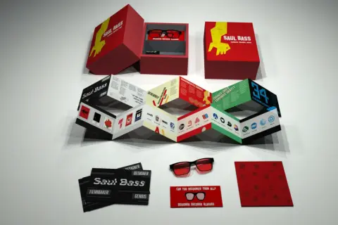 A Saul Bass designs kit, featuring a box with glasses, a folded booklet showcasing his iconic work, and cards.