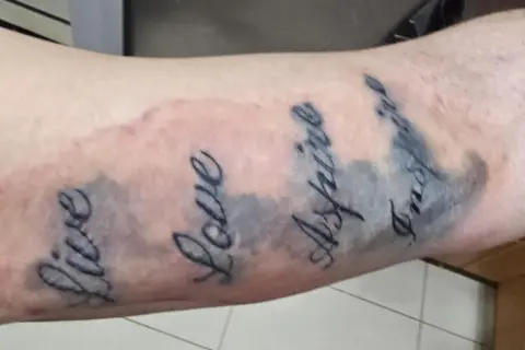 Tattoo mit den Worten "Live", "Love", "Aspire", "Inspire". Die Linien sind etwas unscharf, was auf einen Tattoo Blowout oder eine normale Heilung hindeuten könnte.