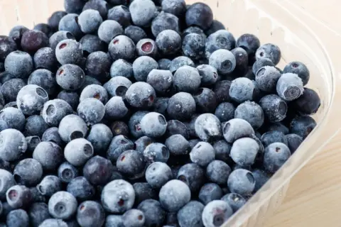 Mrożone borówki amerykańskie w plastikowym opakowaniu. Zastanawiasz się, ile jeść borówki amerykańskiej? Te małe owoce to prawdziwa bomba witaminowa!