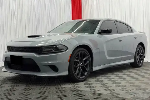 Szary Dodge Charger Hellcat z czarnymi felgami i przyciemnianymi szybami stoi na kratkowanej podłodze.