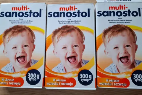 Trzy opakowania multi-sanostol wycofany, z uśmiechniętym dzieckiem, na syrop dla dzieci.