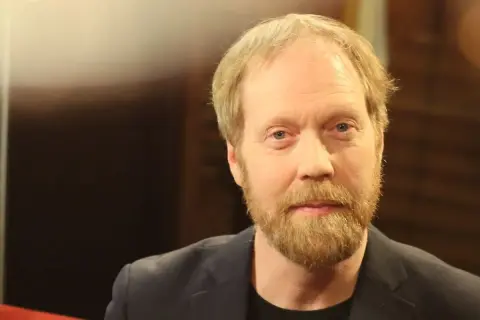 Lars Johan Åge, en man med blont hår och skägg, blickar mot kameran.