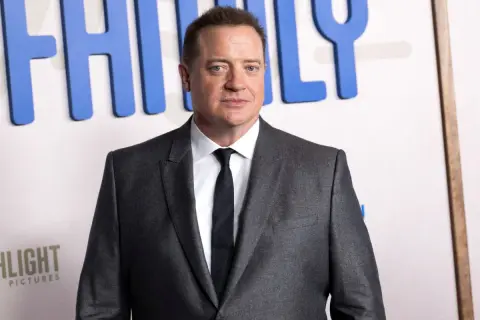 Brendan Fraser w garniturze, z widocznym napisem "FAMILY" w tle. Aktor pokonał chorobę i wrócił na czerwony dywan.
