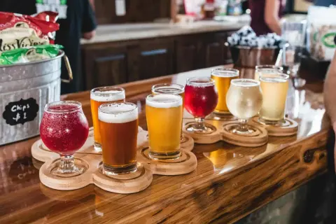 Bierverkostung mit verschiedenen Sorten in Gläsern auf Holztabletts. Perfekte trinktemperatur für jedes Bier.