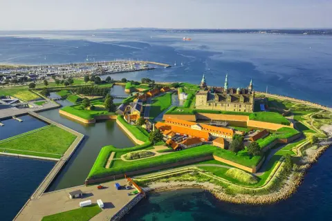 Kronborgs slott vid havet, en stjärnformad fästning med vallgravar och gröna ytor. En idyllisk vy över december i Danmark.