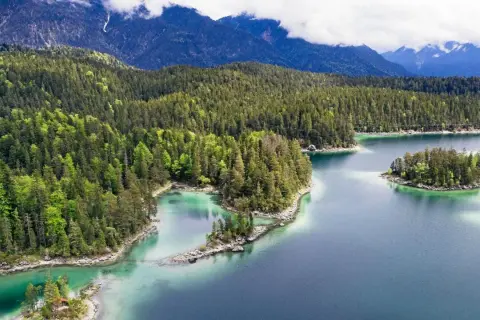 Idyllischer Bergsee mit Inseln, umgeben von dichten Wäldern. Perfekt für einen erfrischenden Tag zum schwimmen.