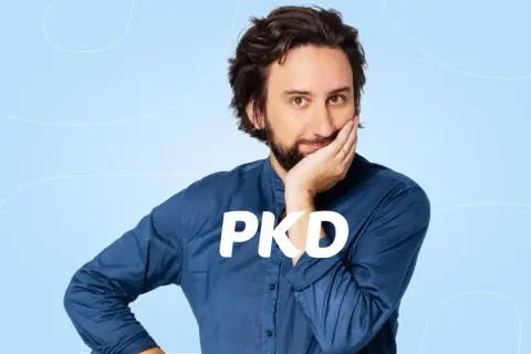 Mężczyzna zamyślony nad tym, jak sprawdzić kody PKD firmy. Napis PKD na jego koszuli.
