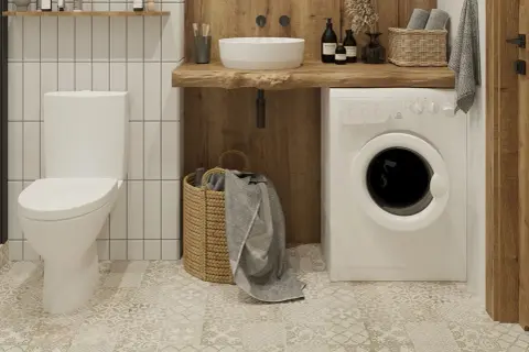 Nowoczesna łazienka z białym, kompaktowym WC narożnym, pralką i drewnianym blatem.
