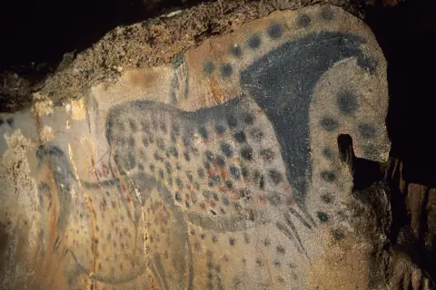 Peintures rupestres des grottes du Pech Merle : un cheval tacheté noir et rouge, une œuvre d'art préhistorique.