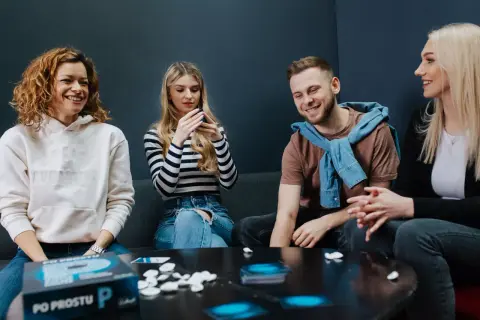 Grupa przyjaciół śmieje się, grając w grę słowną "Po Prostu P".