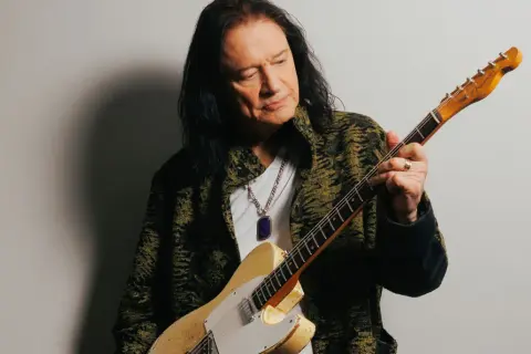 Musician Todd Rundgren, with his signature long dark hair, holds a vintage Fender Telecaster. His career has undoubtedly contributed to his impressive reb beach net worth.
