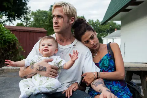 Ryan Gosling barn i famnen, med Eva Mendes vid sin sida. En stund av familjefrid trots omgivningen.