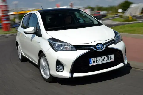 Biała Toyota Yaris 1.3 benzyna w ruchu. Zastanawiasz się, ile pali Toyota Yaris 1.3 benzyna? Ten model jest znany z oszczędności.