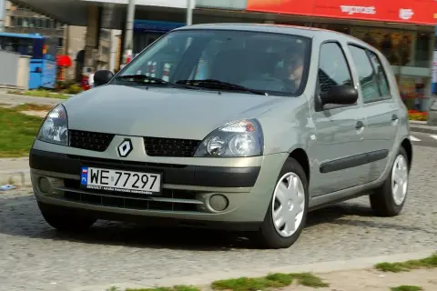 Srebrny Renault Clio 2 z polskimi tablicami rejestracyjnymi WE 77297 jedzie po miejskiej ulicy.