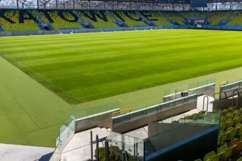 Nowy stadion GKS Katowice, z zieloną murawą i żółto-czarnymi trybunami, czeka na kibiców. Lokalizacja obiektu to ul. Bukowa 1.
