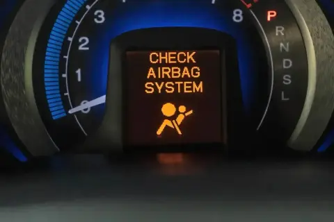 Na desce rozdzielczej świeci się pomarańczowa kontrolka poduszki powietrznej z napisem "CHECK AIRBAG SYSTEM".