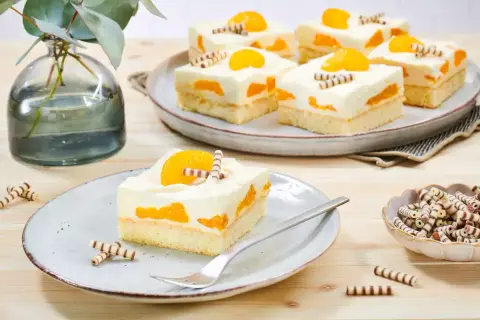 Saftiger Mandarinen Schmand Kuchen Blech, dekoriert mit Mandarinenstücken und Schokoröllchen. Ein Genuss für Augen und Gaumen!