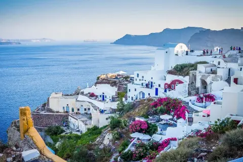 Santorini, Grecja. Czy do Grecji potrzebny jest paszport? Tak, jeśli nie jesteś obywatelem UE. Białe domy, niebieskie drzwi, morze.