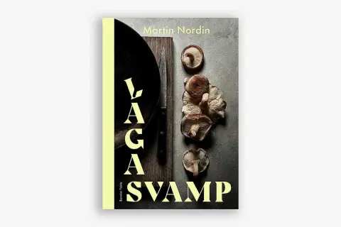 Boken "Laga svamp" av Martin Nordin visar en samling färska svampar, en kniv och en stekpanna. Perfekt för svamp mat-entusiaster.