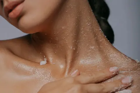 Delikatny peeling z **sodium lactate** na szyi i dekolcie. Skóra nawilżona i gładka.