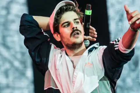 Taco Hemingway, znany z charakterystycznego wzrostu i stylu, na koncercie.