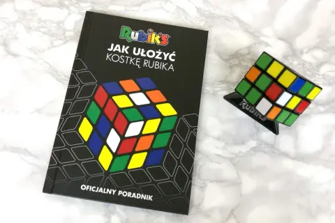 Książka "Jak ułożyć kostkę Rubika" i kostka Rubika na podstawce. Oficjalny poradnik dla początkujących.