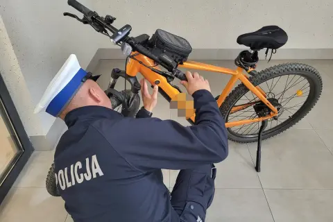 Policjant sprawdza, czy na rower elektryczny trzeba mieć prawo jazdy. Pomarańczowy rower górski z bagażnikiem.