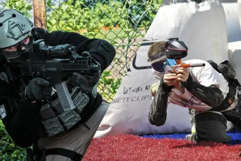 Dos jugadores, uno en airsoft paintball, se preparan para la acción.