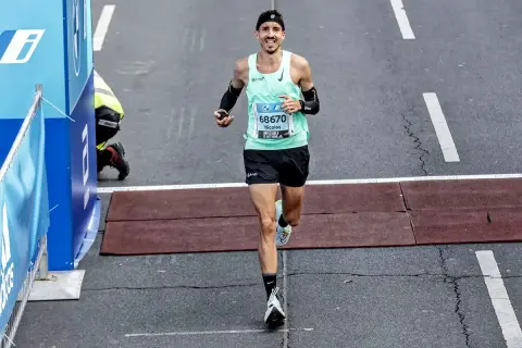 Nicolas franchit la ligne d'arrivée, son kit marathon impeccable. Il a l'air épuisé mais heureux.