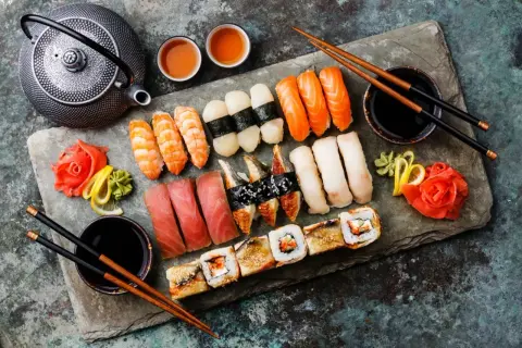 Idealny zestaw do sushi: nigiri z łososiem, krewetkami, tuńczykiem, makrelą i rybą maślaną, a do tego rolki i tradycyjne dodatki.