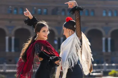 Dos mujeres bailan flamenco con mantones. ¡Perfecto para clases de flamenco para adultos!