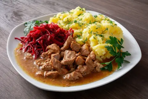 Gulasz z łopatki wieprzowej w sosie własnym, podany z purée ziemniaczanym i buraczkami. Pyszny, domowy obiad.