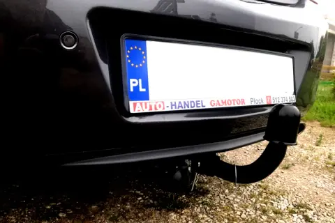 Widok z tyłu samochodu Opel Insignia z zamontowanym modułem haka. Widoczna tablica rejestracyjna i czujnik parkowania.
