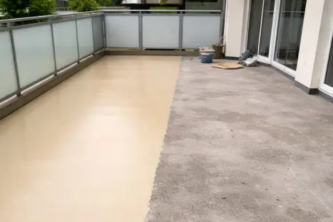 Balcone con pavimenti in resina per esterni: metà grezzo, metà beige applicato. Valutare pro e contro per una scelta informata.