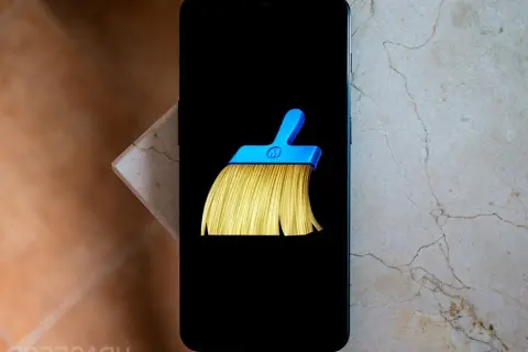 Un teléfono muestra el icono de una escoba azul y amarilla, símbolo del mejor limpiador de móvil gratis.