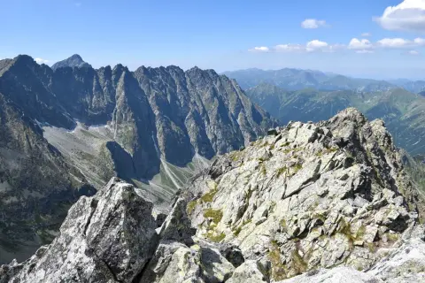 Kamienista grań na trasie na Koprowy Wierch. Majestatyczne szczyty Tatr Wysokich w tle.