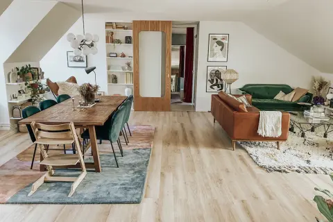 Två mattor i samma rum: en stor, abstrakt matta under matbordet och en mindre, mönstrad matta framför soffan.
