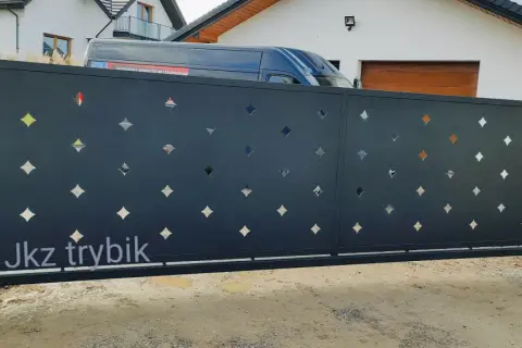 Nowoczesna brama przesuwna z ażurowym wzorem w kształcie rombów, idealna do posesji o standardowych wymiarach.
