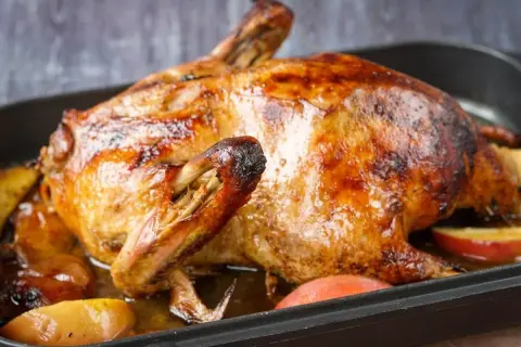 Goldbraune Ente mit Äpfeln im Bräter, perfekt gegart mit Umluft oder Oberhitze.