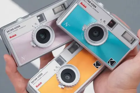 Trzy kolorowe aparaty jednorazowe Kodak Ektar H35N w dłoniach. Dowiedz się, jak działa aparat jednorazowy, by uchwycić wspomnienia.