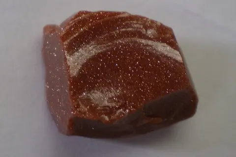 Ein glitzernder goldfluss edelstein mit schimmernden Einschlüssen, der wie ein Sternenhimmel aussieht.
