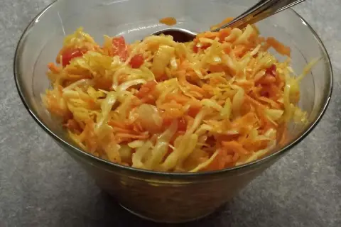 En skål med kålsallad, morötter och tomatbitar. Perfekt som tillbehör till middagen, en riktig 3 veckors sallad!