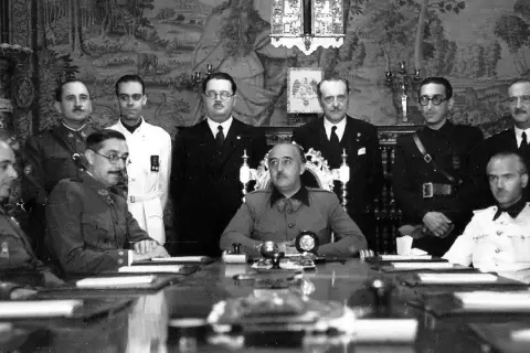 Luis Alarcón de la Lastra, rodeado de militares y civiles, en una reunión formal.
