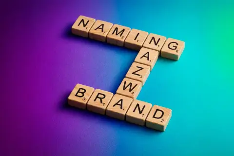 Drewniane klocki z literami tworzą słowa "NAMING" i "BRAND". To klucz do sukcesu każdej firmy.