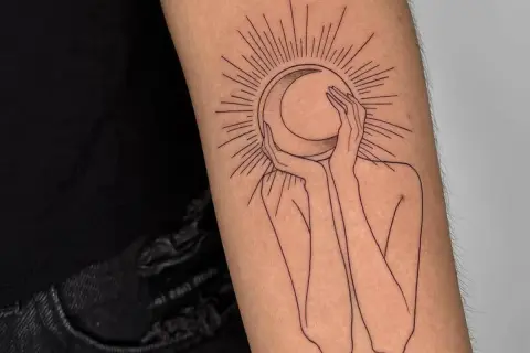 Un tatuaje de una figura abstracta abraza una luna creciente, rodeada por rayos solares. Un diseño minimalista que evoca misterio y conexión cósmica.