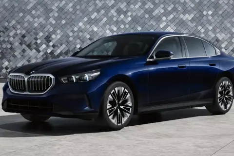 Eleganckie, granatowe bmw 520 z nowoczesnym designem, stojące na tle geometrycznej ściany.